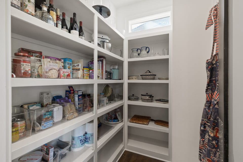 A foodie`s retreat, this bright and perfectly ordered walk-in pantry is generously stocked and even has a custom hook for your favorite chef`s apron.