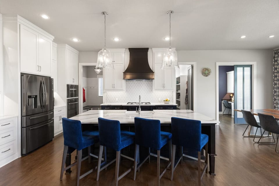 A bright, open-concept kitchen featuring a spacious island with elegant quartz countertops and plush seating—perfect for gathering, dining, and entertaining.