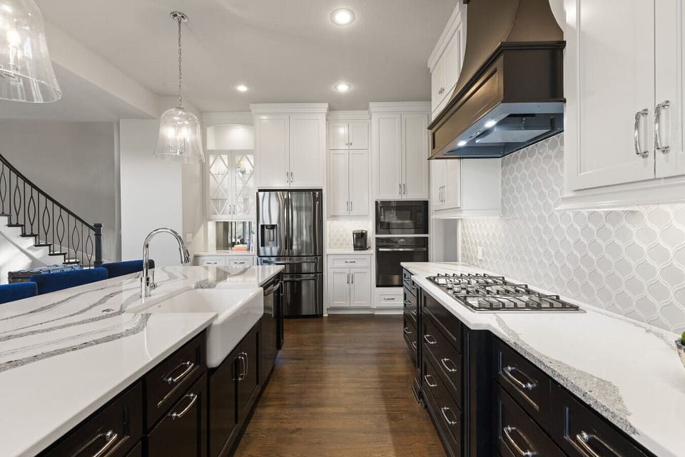 A sleek chef’s kitchen with modern appliances, ample counter space, and warm wood flooring—designed for both style and functionality.