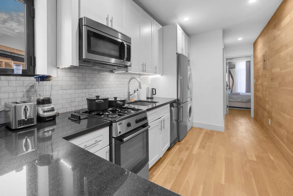 Modern kitchen with full appliances and in-unit washer/dryer.