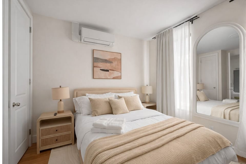 Bright bedroom with cozy bed, soft tones, and modern comforts