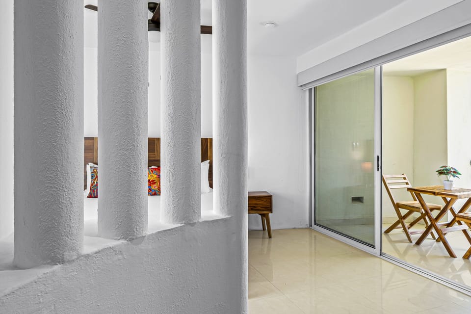 Bright and airy bedroom entrance with direct access to the private balcony, creating a peaceful indoor-outdoor atmosphere throughout the space.