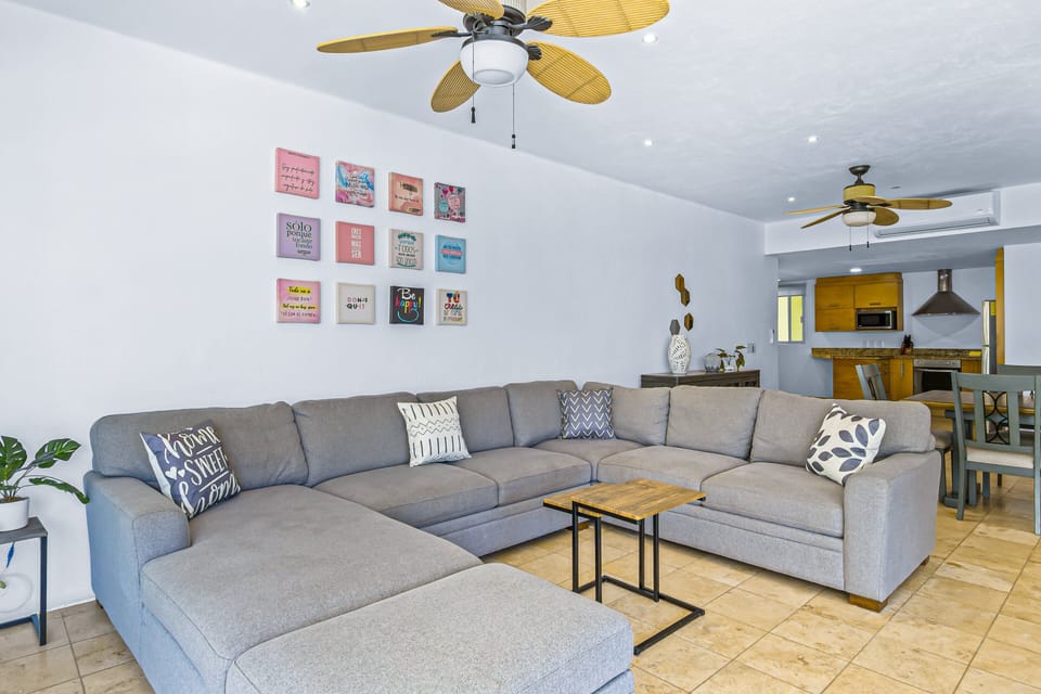 Spacious living room with large sectional sofa, natural light, and open layout ideal for relaxing and gathering with family or friends.