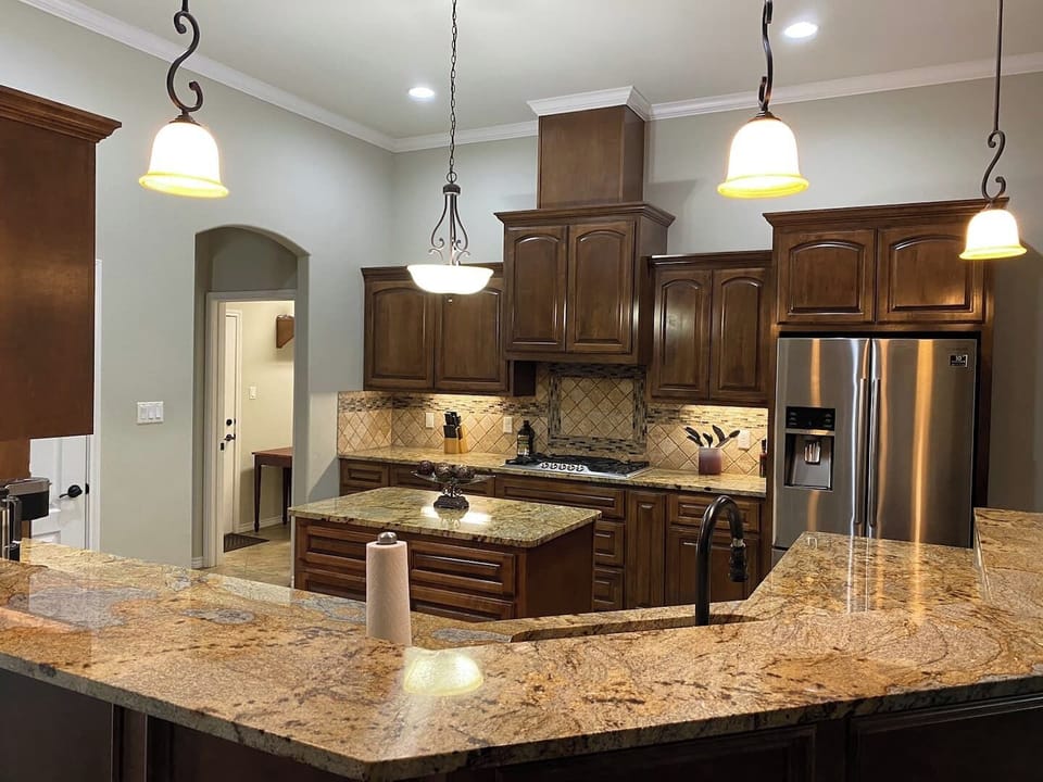 Fully equipped kitchen featuring stainless steel appliances, a chef's gas range, and ample cabinet storage. Ideal for cooking meals during extended stays.