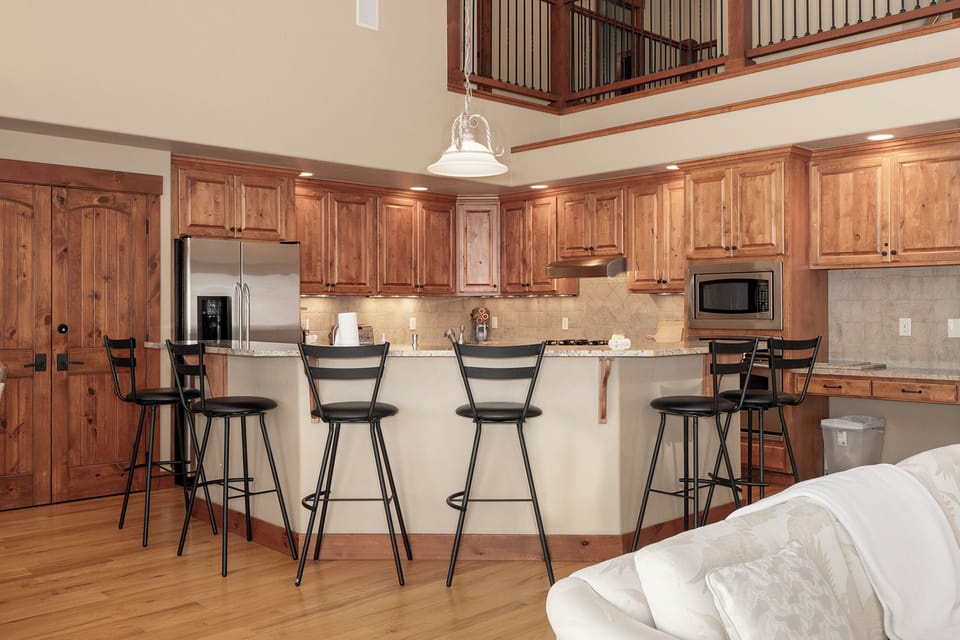 Your spacious gourmet kitchen features rich wood cabinetry, granite counters, and a breakfast bar where you can savor morning coffee together.