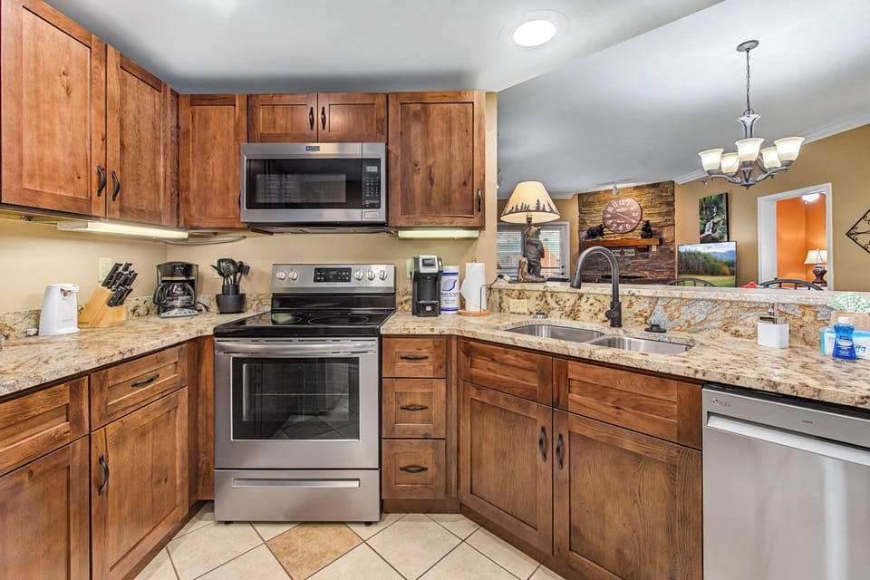 Whip up your favorite meals in this fully-equipped kitchen featuring granite counters, stainless appliances, and rustic wood cabinets.