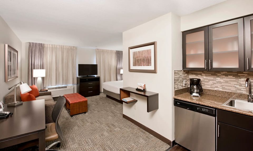 The studio layout features a king bed, sleeper sofa, and in-suite work desk.