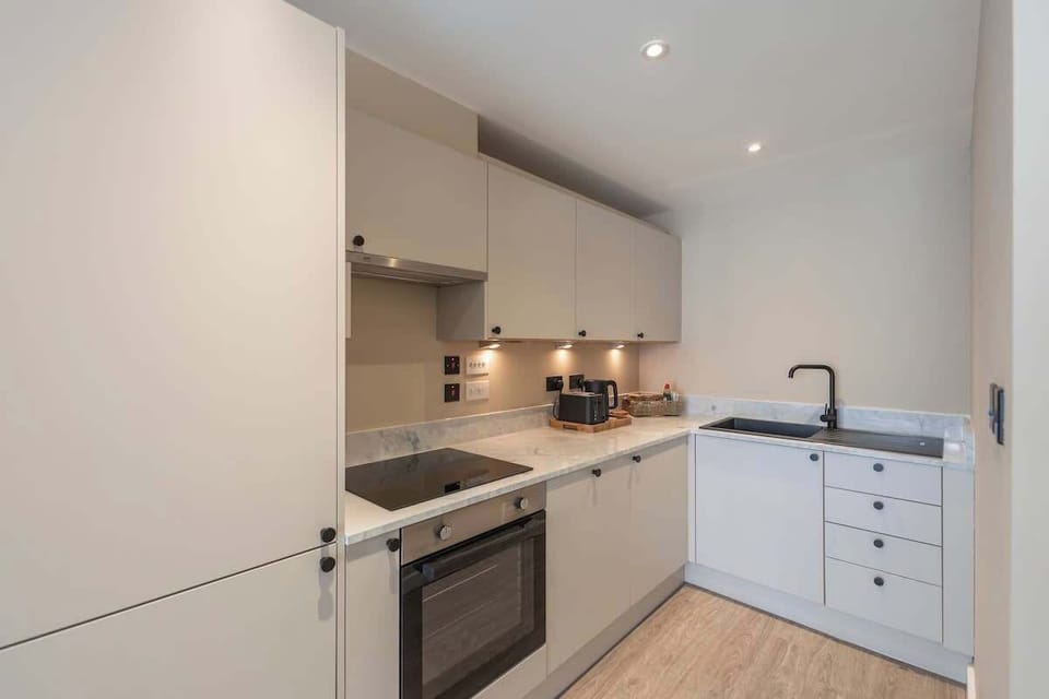 Stylish open-plan living space with a modern kitchen, sleek cabinetry, and warm wood finishes throughout.