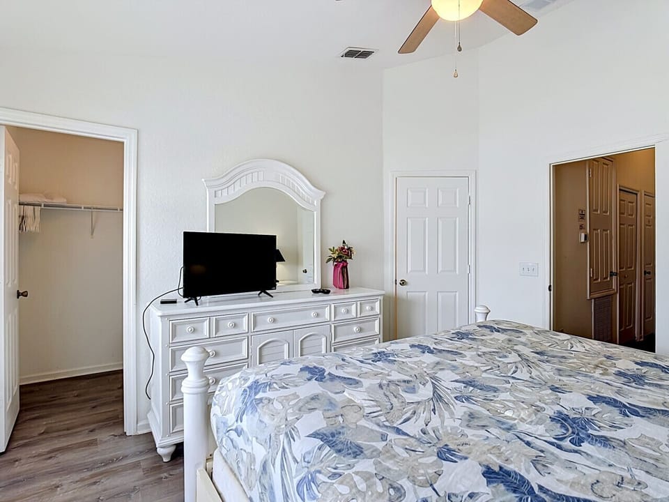 Spacious master bedroom with TV and dresser.
