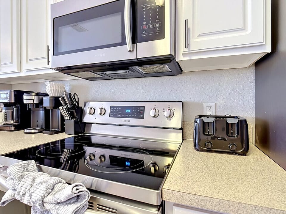 Modern kitchen with stove, coffee maker, and toaster.