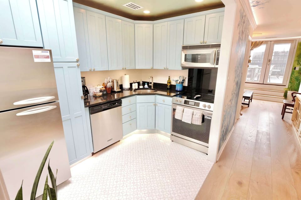 Kitchen framed by blue landscape murals, blending everyday convenience with a gallery‑like backdrop.
