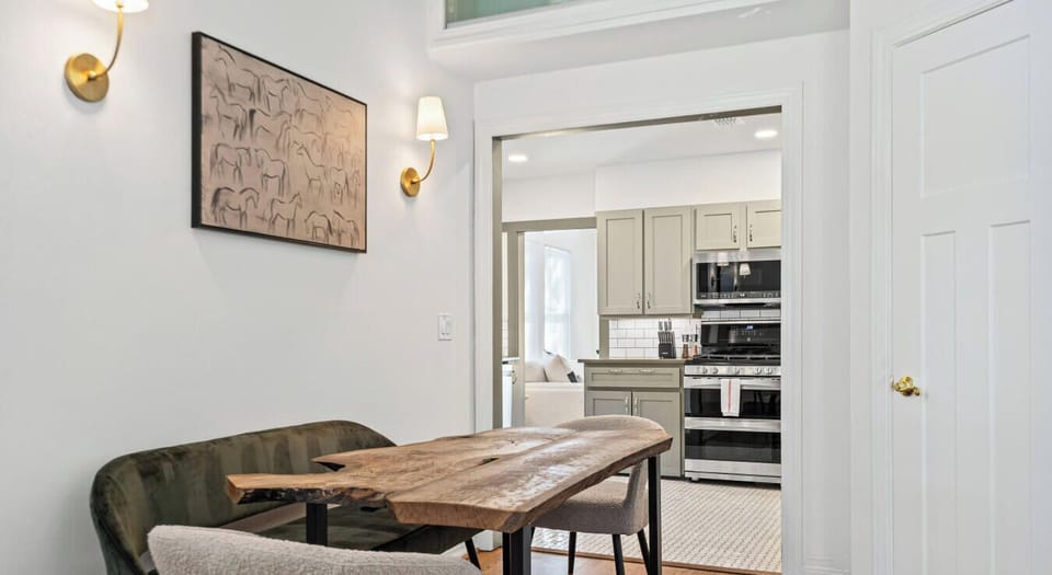 The dining space connects directly to the kitchen for easy entertaining. Warm sconces set a welcoming mood.