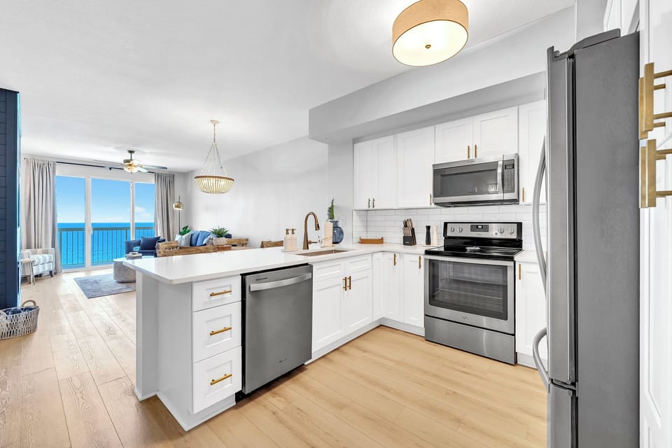 A fully updated kitchen featuring stainless steel appliances, including a full-size refrigerator, oven, microwave, and dishwasher—everything you need for easy, stress-free meals during your stay.