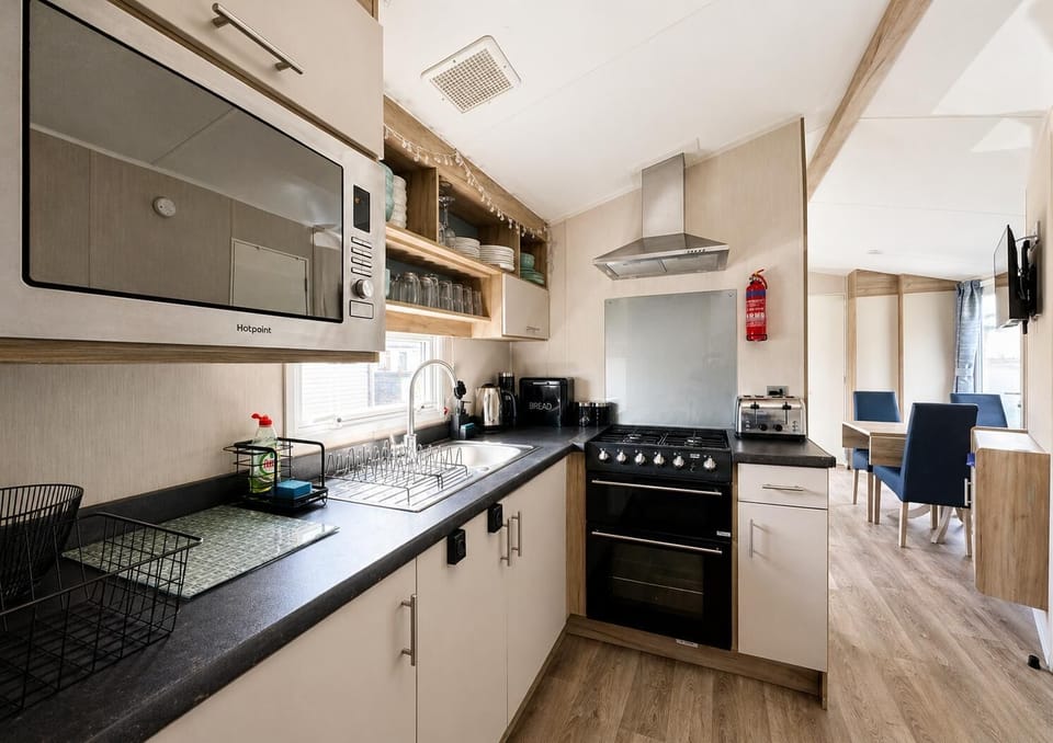 The kitchen in this modern caravan is the perfect place to prepare the family favourites. With oven, hob, grill and microwave you will have all the applicances needed to cook up a storm.