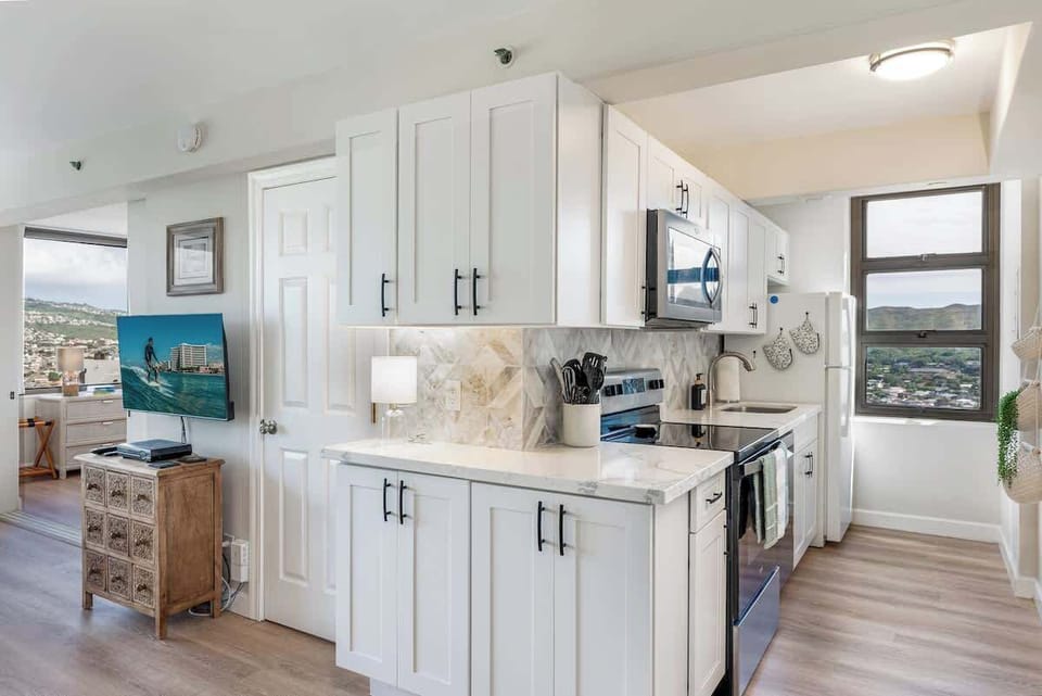 Full kitchen, door to the bathroom, Tv area, and bedroom entry