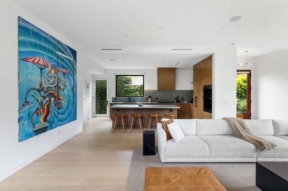 Spacious living room with a seamless view of the dining area, featuring a striking big wall art painting that adds character to the space.