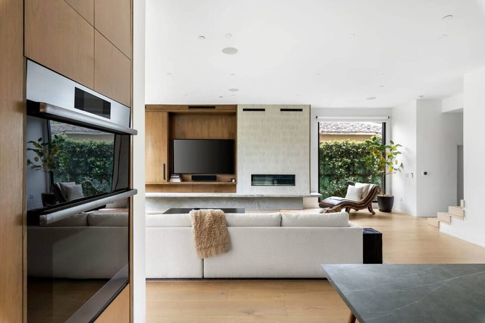 Cozy living room featuring a wooden coffee table, two chairs, and a fabric couch. Enjoy entertainment with smart TVs on both the first and second floors.