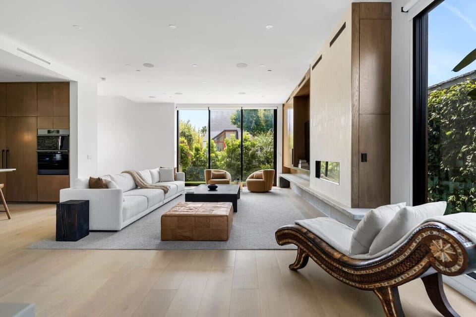 Cozy living room featuring a wooden coffee table, two chairs, and a fabric couch. Enjoy entertainment with smart TVs on both the first and second floors.