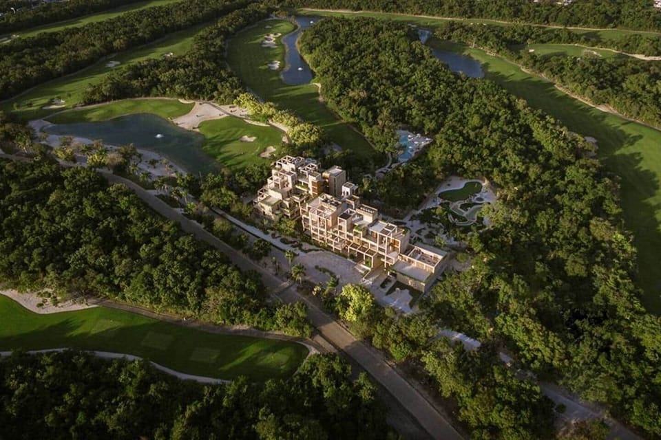 Aerial view of the complex showcasing its beautiful surroundings, nestled within the Gran Coyote Golf Course and featuring mini golf and lush greenery throughout, creating a peaceful and scenic environment.