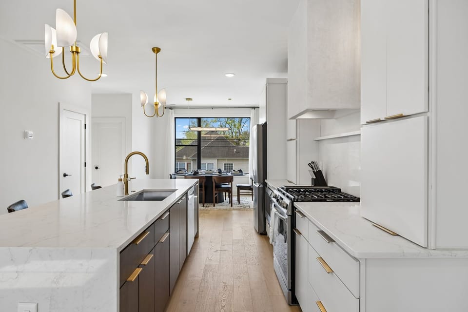Kitchen: A spacious kitchen featuring a large island, bar stools, and pendant lights above.