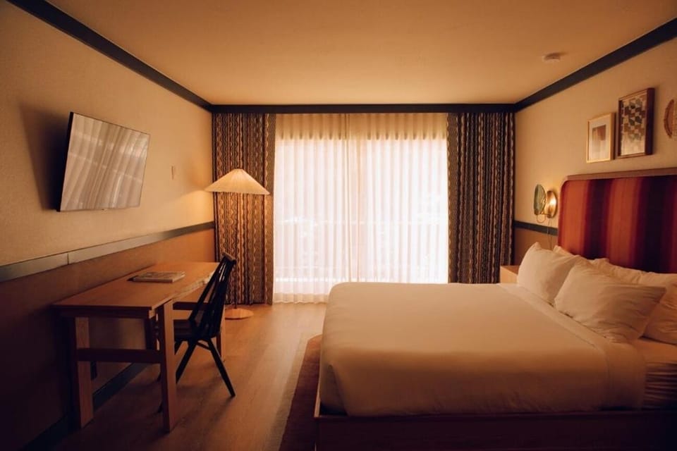 Settle in for a cozy night with desk and big windows.