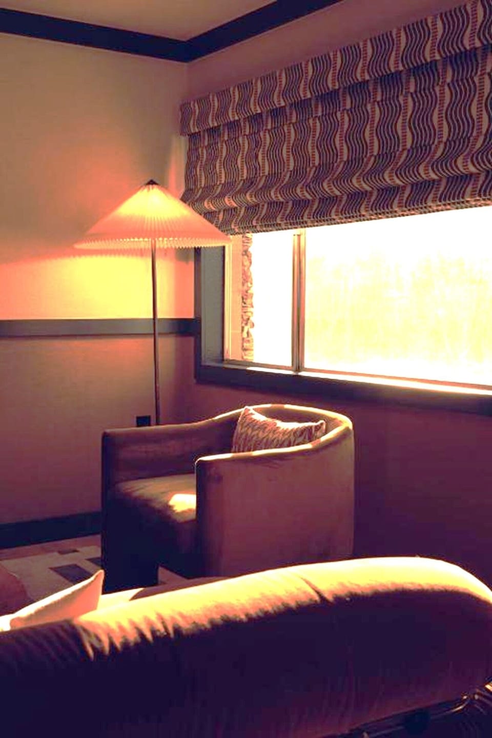 Relax by the window with a cozy chair and soft glow.