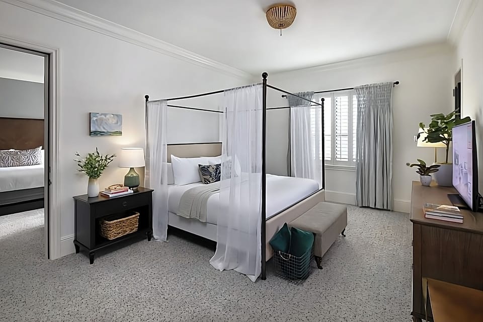 Drift off in a serene canopy bed with soft light.