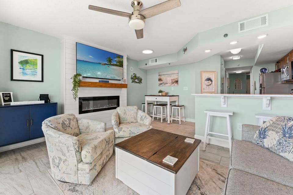 Living room with adjacent dining area.  Cabinet to the left of the TV has books and some games.