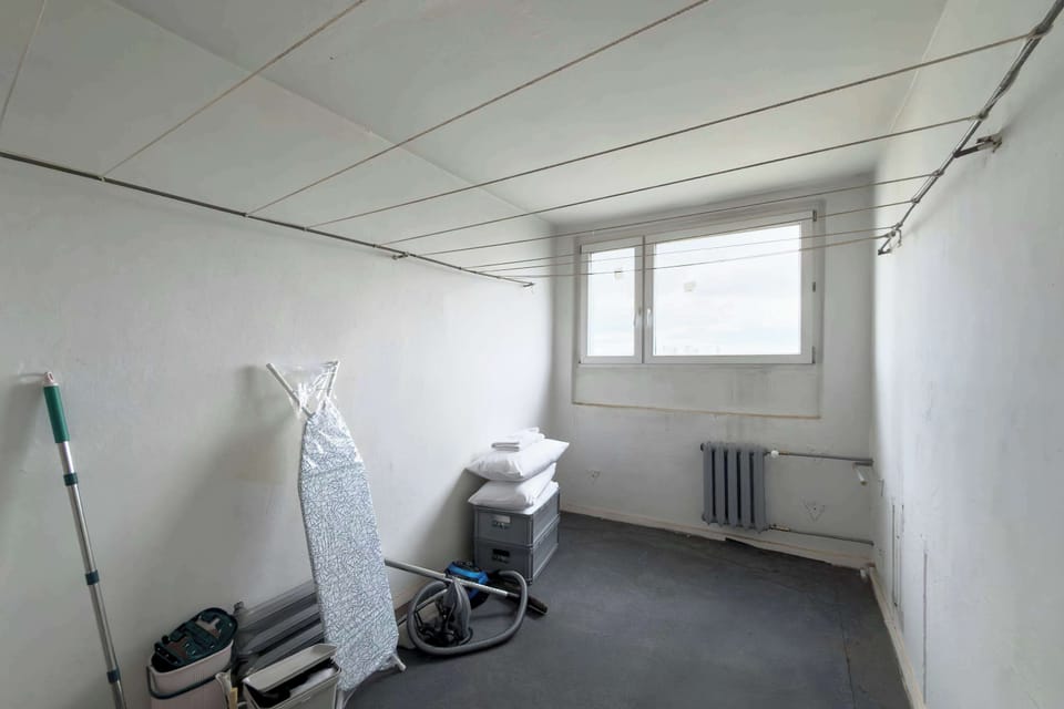 An enclosed drying room designed specifically for drying clothes, with large windows providing plenty of natural light. The space is simple and functional, offering enough room for laundry racks and everyday use. 