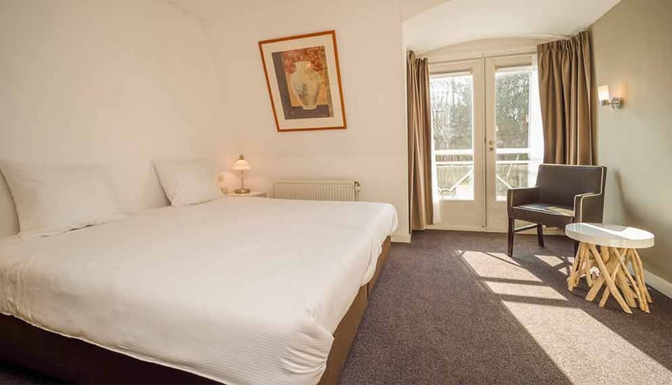 Sink into plush bedding with calming daylight and quiet views.