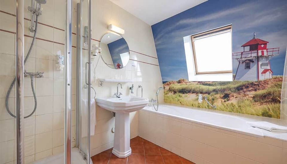 Soak under the skylight beside a playful coastal mural.