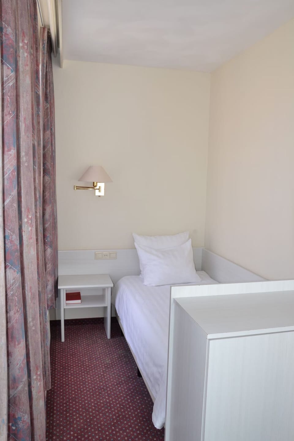 Unwind in a cozy single room with bedside light.
