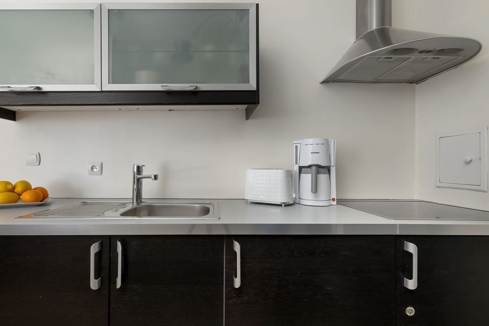 Close-up of the kitchen with counter appliances and storage cabinets. A modern and minimalist design.