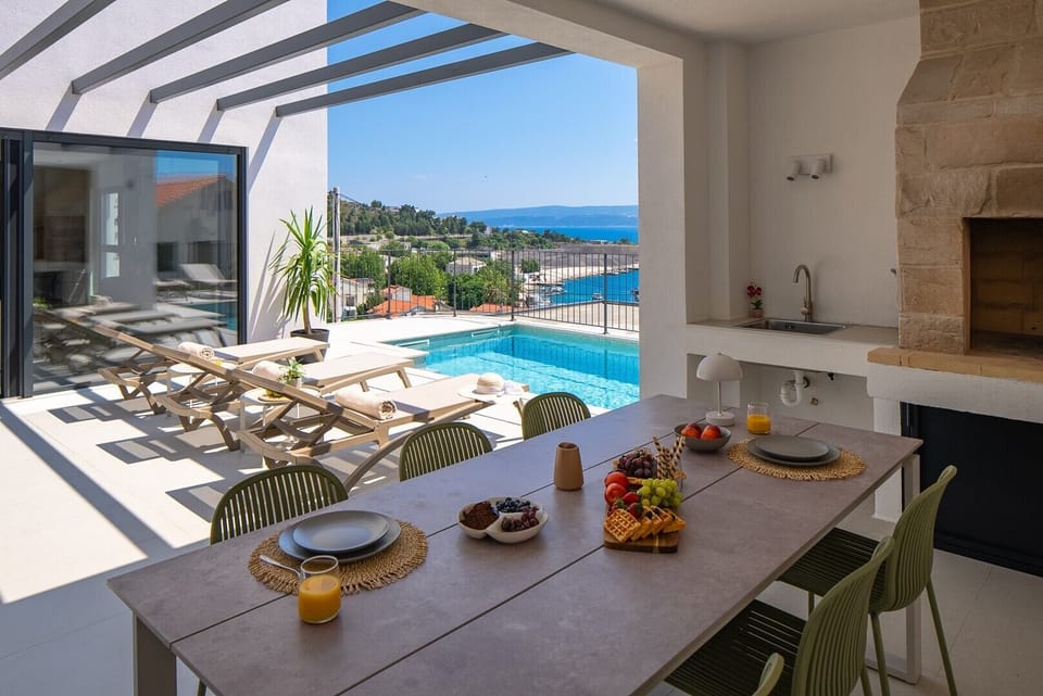The covered outdoor dining area features a barbecue for enjoying al fresco meals with sea views.