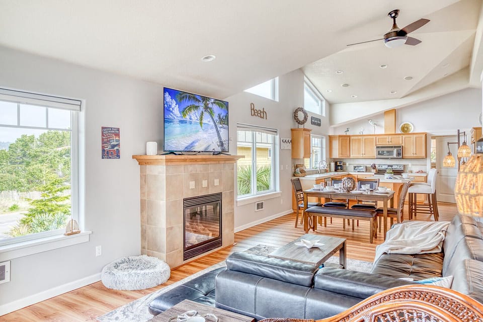 Relax in your open-concept living space with cozy fireplace, modern kitchen, and natural light streaming through large windows.