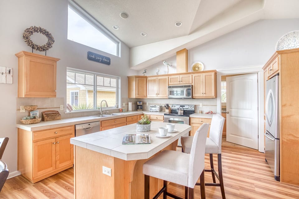 Cook with joy in this bright, fully-equipped kitchen featuring granite countertops, stainless steel appliances, and a cozy breakfast island.