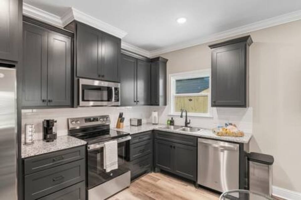 Whip up culinary delights in this spacious, modern kitchen. Gleaming stainless steel appliances, ample counter space, and bright lighting make cooking a joy for couples and families alike. 