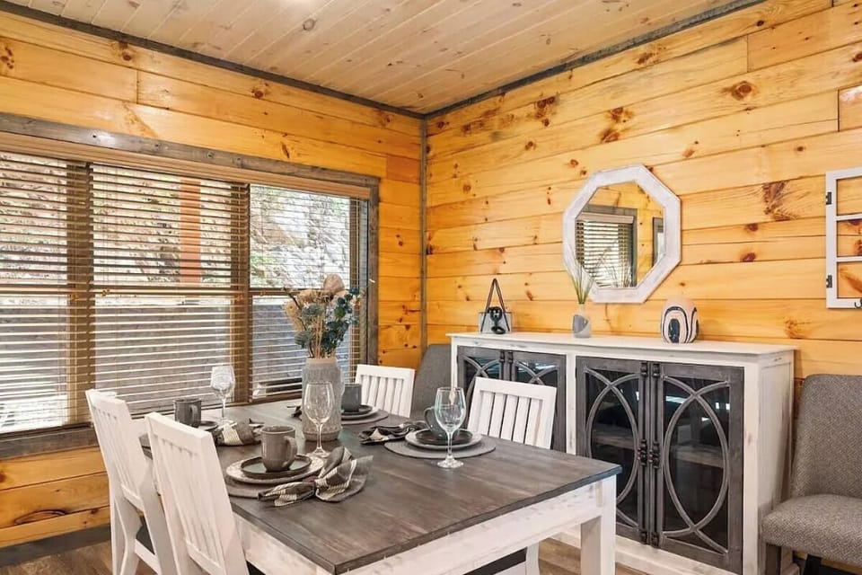 Your cozy dining space features warm wood walls and elegant table settings, perfect for intimate meals together.