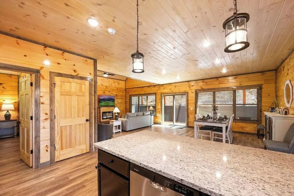 You'll love cooking in this spacious kitchen with granite countertops, rustic wood beams, and charming pendant lighting creating a warm mountain retreat atmosphere.