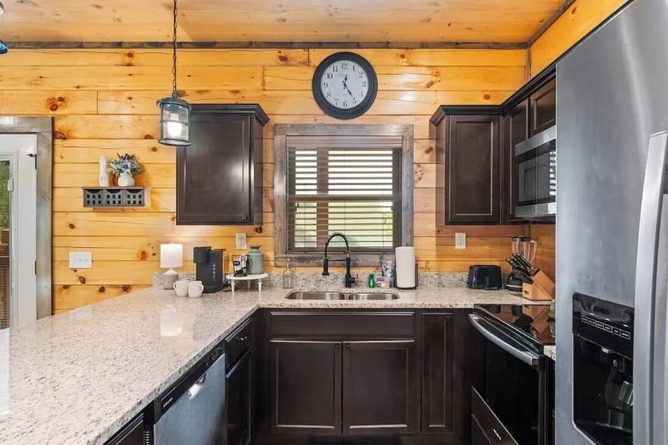 Your rustic-chic kitchen combines warm wood walls with granite counters, complete with stainless appliances for effortless meal prep.
