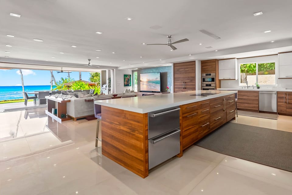 Picture yourself in this stunning oceanfront kitchen where you'll cook and gather against a backdrop of endless blue sea views. The sleek chef's kitchen flows seamlessly to your own private paradise outside.
