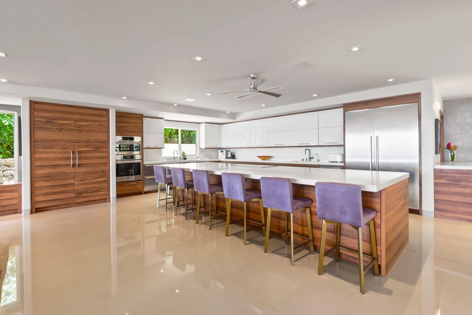 Your spacious gourmet kitchen features a stunning island with seating for six, sleek modern appliances, and elegant wood accents perfect for preparing memorable meals together.