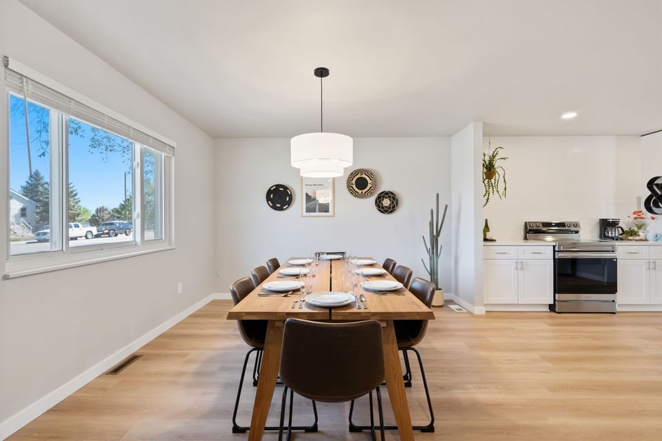 Gather around your spacious dining table for memorable meals in this bright, modern space with warm wood floors and stylish pendant lighting.