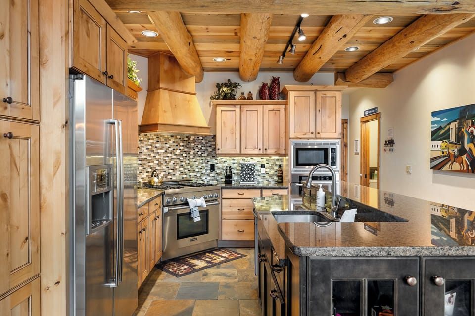 Your gourmet kitchen features stunning exposed beams, granite counters, and premium appliances for memorable mountain meals.