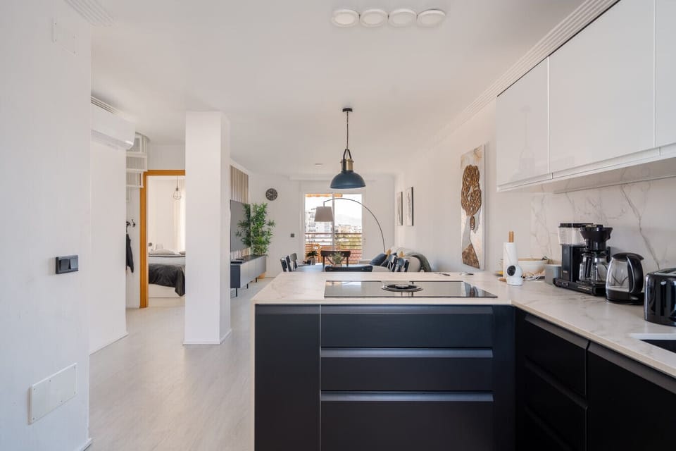 Our open-plan kitchen design ensures you can stay part of the conversation in the living area while preparing meals or drinks. The sleek marble-style countertops and induction stove provide a luxurious space for any home chef to enjoy.