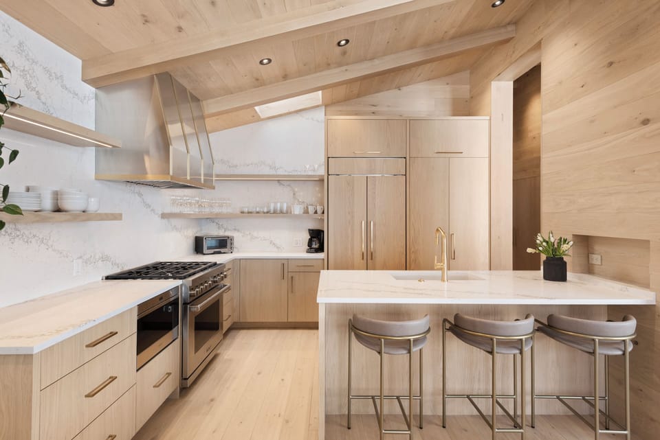 Fully equipped kitchen with natural stone countertops, custom cabinetry, and high-end appliances including a Wolf Range.