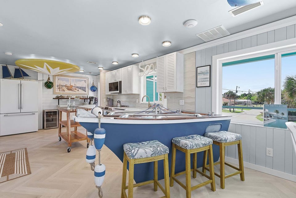 One-of-a-kind coastal kitchen featuring a boat-shaped bar, modern appliances, and bright design. Perfect for a beach stay, this fun and functional space is ideal for dining, gathering, and making lasting vacation memories.