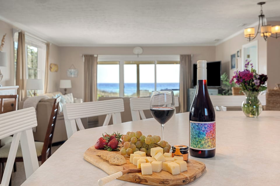 Bright modern kitchen with light wood cabinetry, stainless steel appliances, and a welcoming island set for wine and bites.