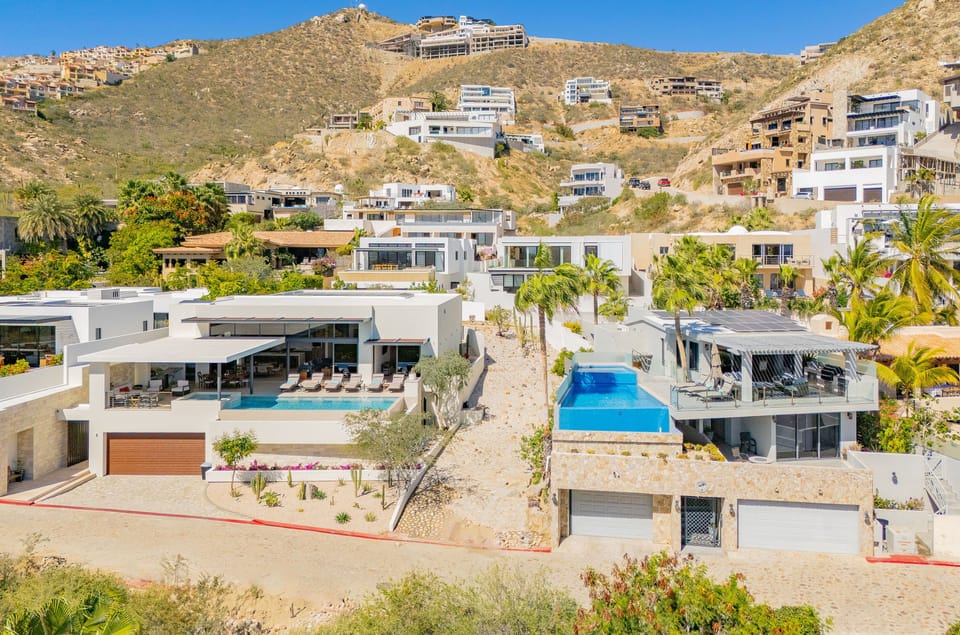 Modern hillside villas showcase stunning architectural design with private pools nestled among desert landscape and tropical palms.
