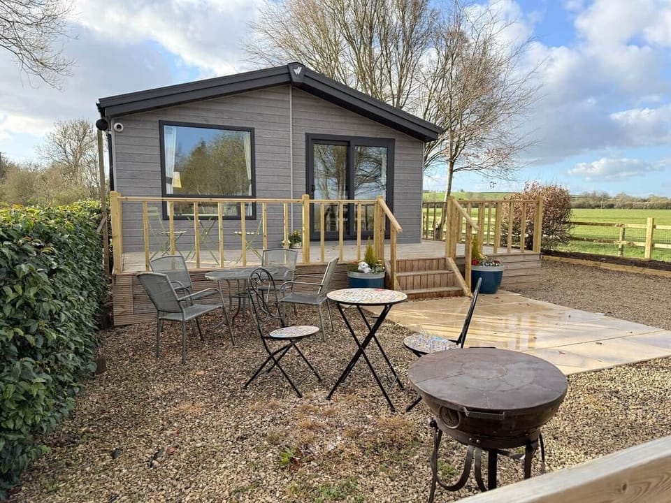 Outdoor dining area with Kadai fire bowl, BBQ, and ample seating at Fleece Lodge, Chad Lakes.